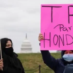 Persona sostiene un cartel de TPS para Honduras durante una manifestación en Estados Unidos